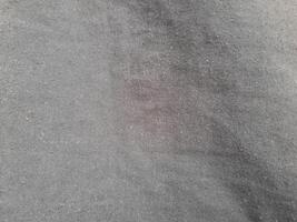 a close-up view of a smooth, black-colored fabric. The texture is fine and uniform, creating a soft and elegant appearance with no visible patterns or folds photo