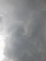 an overcast sky dominated by dense gray clouds, creating a moody and atmospheric scene. The soft light filtering through the clouds hints at possible rain or stormy weather. photo