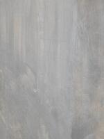 A plain gray textured surface with subtle irregular patterns and faint lines. The surface has a smooth yet natural appearance, resembling concrete or plaster with slight imperfections. photo