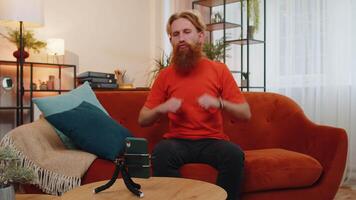 Bearded man blogge taking selfie on smartphone dancing, recording vlog for subscribers at home video