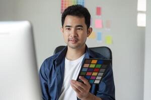 Graphic Designer Strategizing Creative Project with Color Palette in Modern Office Environment photo