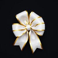 White and gold bow on black background photo