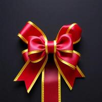 Red and gold bow on black background photo