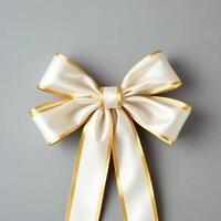 A white and gold bow on a gray background photo
