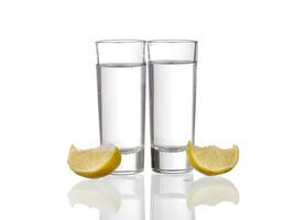 Three tequila shots with lime isolated on white background photo