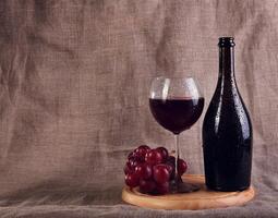Red wine, cheeses and grapes in a still life setup. photo