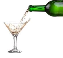 White wine pouring from the bottle intro the glass on white background photo
