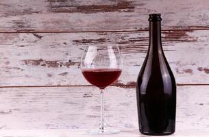 Red wine bottle on a wooden background photo