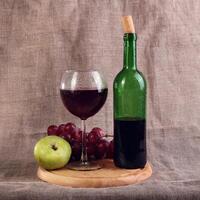 Red wine, cheeses and grapes in a still life setup. photo