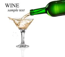White wine pouring from the bottle intro the glass on white background photo