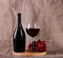 Red wine, cheeses and grapes in a still life setup. photo