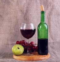 Red wine, cheeses and grapes in a still life setup. photo