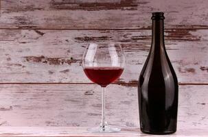 Red wine bottle on a wooden background photo
