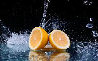 Sliced lemon in the water on black background photo