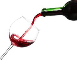 Red wine pouring on white background photo