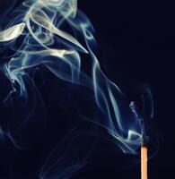 cyan smoke comes out from an extincted match photo
