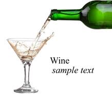 White wine pouring from the bottle intro the glass on white background photo