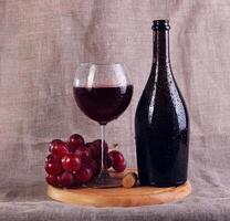 Red wine, cheeses and grapes in a still life setup. photo