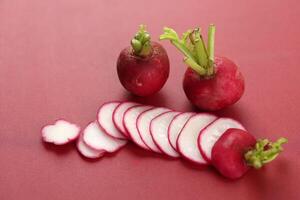 Sliced Red Radish on Red Background photo