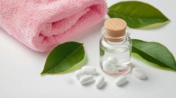 White tablets and a towel placed next to a glass jar on a clean surface photo