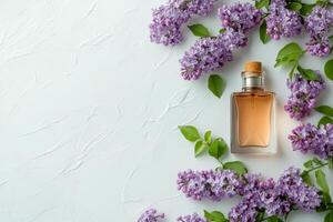 Perfume bottle surrounded by lilac flowers on a bright white background in springtime photo