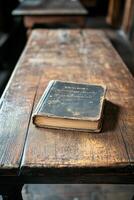 An antique book resting on a weathered wooden table in a cozy, dimly lit room photo