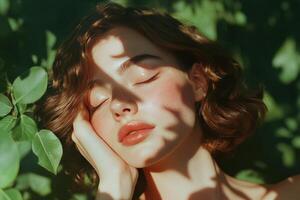A young woman with curly hair relaxes with her eyes closed, gently resting her hand on her face photo