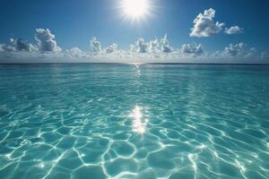 Serene turquoise ocean under bright sun reflects clouds and waves at midday by the coast photo
