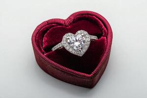 Beautiful heart shaped diamond ring in a red velvet jewelry box on a light background photo