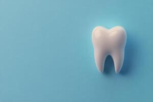 A realistic tooth model on a blue background highlighting dental health and hygiene importance photo
