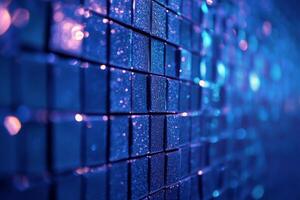 Close up view of shimmering blue tiles arranged in a square pattern on a wall photo