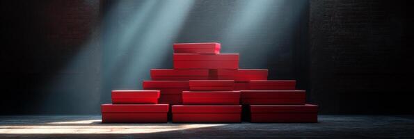 A stack of red gift boxes on a wooden table in a cozy, dimly lit room decorated for the holidays photo