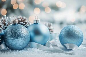 Shimmering blue Christmas ornaments arranged on sparkling snow like surface with soft bokeh lights photo