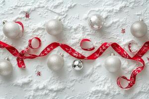 Silver ornaments and red ribbons on snow make a festive holiday decoration photo