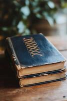 Sunlight casts shadows on an open book resting on a wooden table near a vintage window photo