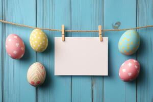 Colorful decorative Easter eggs hanging on a string against a blue wooden background photo
