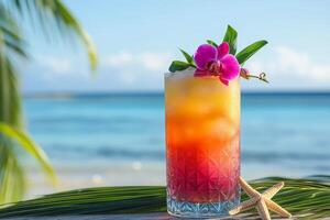 A colorful tropical drink with a flower garnish beside a serene ocean view during the day photo