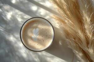 A cozy cup of cappuccino placed on a soft surface with dried grass in early morning light photo