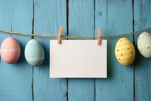 Colorful decorative Easter eggs hanging on a string against a blue wooden background photo