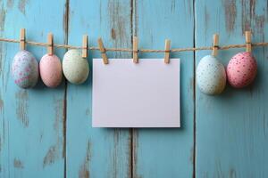 Colorful decorative Easter eggs hanging on a string against a blue wooden background photo