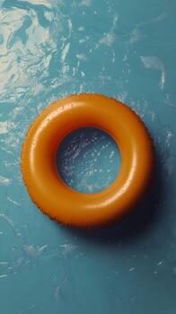 Bright yellow swimming ring floating on clear blue water in a sunny pool setting photo
