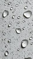 Water droplets on a textured surface creating a shimmering effect in soft light photo