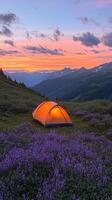 A vibrant tent lights up the dusk in a serene mountainous landscape at twilight photo