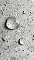 Water droplets on a textured surface creating a shimmering effect in soft light photo