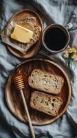 Breakfast setup with whole grain bread, butter, honey, and coffee on a linen tablecloth photo