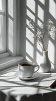 A minimalist coffee cup resting on a white surface with soft shadows in natural light photo