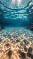 Underwater sunlight beams illuminating sandy ocean floor and coral formations during midday photo