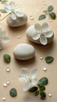 White stones and delicate flowers arranged with droplets on a soft surface during natural daylight photo