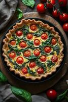Fresh vegetable quiche with spinach and cherry tomatoes on a rustic wooden table photo