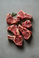 Fresh cut pork chops placed on a gray surface with a sprig of mint for garnish photo